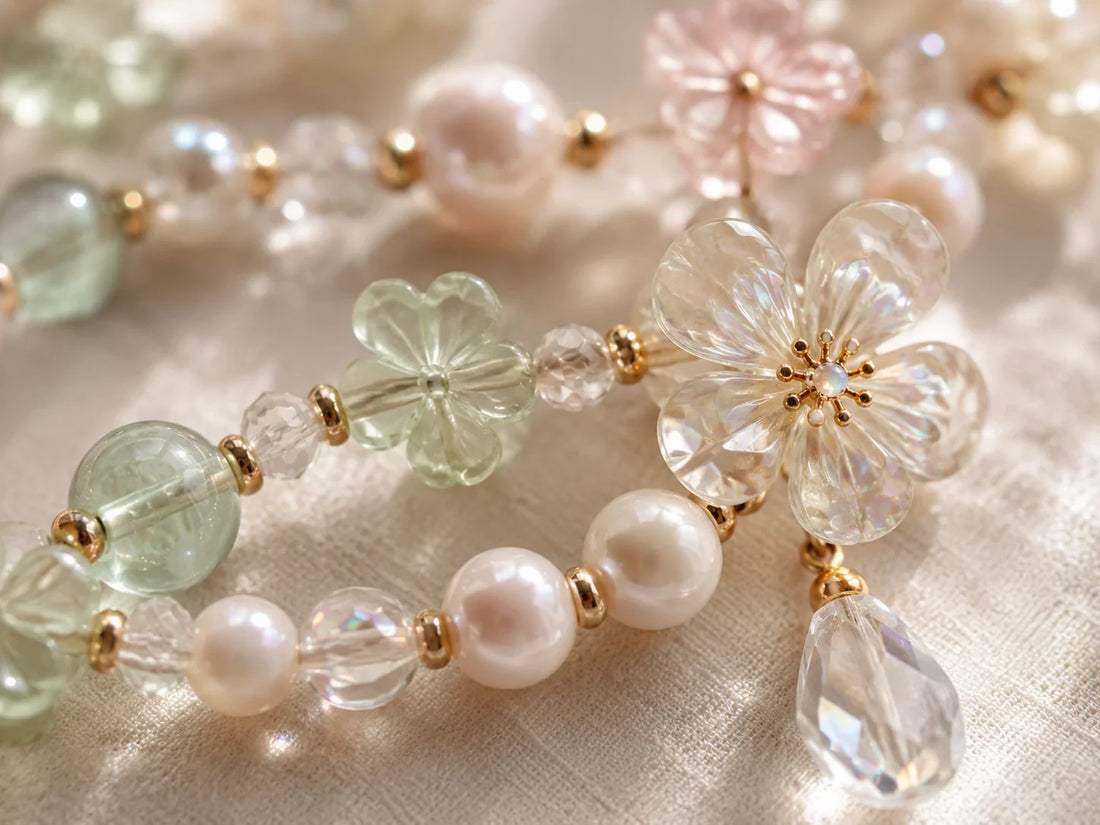 Hand holding a smartphone with a pearl and crystal phone charm attached correctly